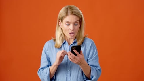 Excited Woman with Smartphone Making Winner Gesture