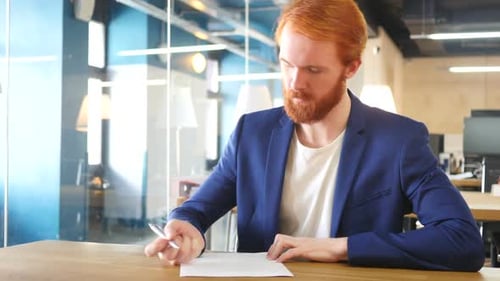 Man Writing Papers in Office