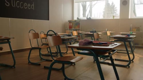 Escritorios y sillas de madera en el aula moderna. Interior de la sala de la escuela con