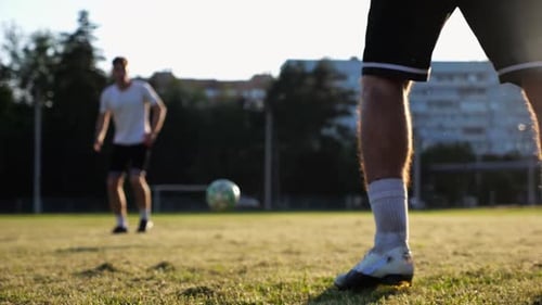Male Feet of Professional Footballers Passing Soccer Ball on Stadium at Sunset Legs of Sportsmen