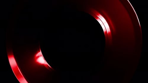 Red metallic torus rotating on black background