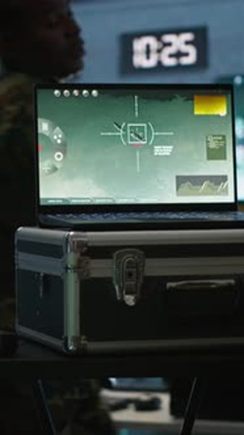 Soldier with Rifle Stands Near Targeting Laptop