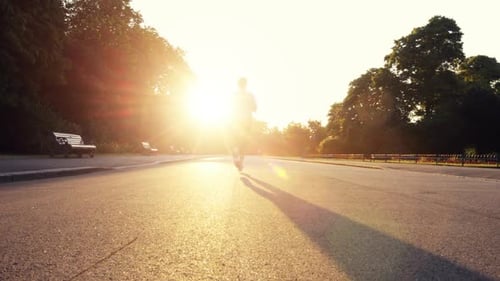 4k video footage of an unrecognizable woman jogging in a road outside