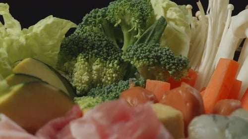 Close Up Of A Pot Of Shabu Ingredients Spinning Around On The Black Background