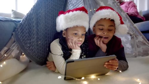 Kids in Santa Hats Watch Tablet in Living Room