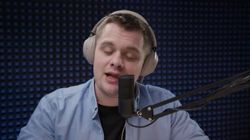 Radio Host Sit in Studio and Communicates with Audience Man in Blue Shirt and Headphones Sits in