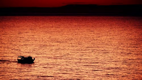 Fischerboot auf See bei Sonnenaufgang