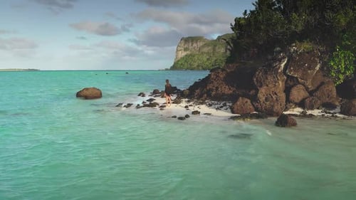 Woman Enjoying Tropical Paradise Standing on White Sand Beach with Turquoise Water Volcanic Rocks