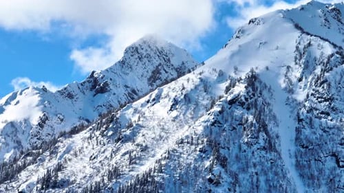 Sharp snow-covered mountain peak against a blue sky