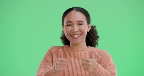 Frau, Gesicht und glücklich mit erhobenen Daumen auf Greenscreen im Studio für positive Abstimmung oder Bewertung