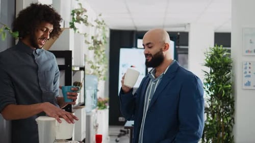 Two Men Chatting and Drinking Coffee in Office