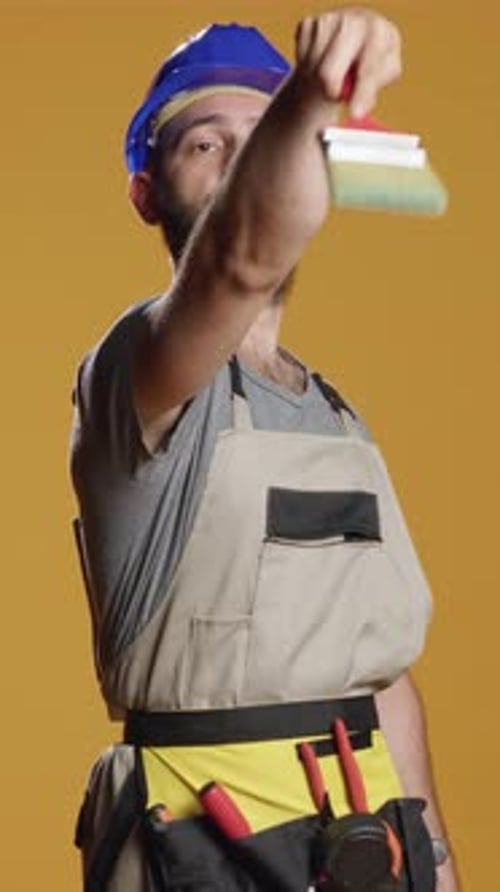 Vertical Video Portrait of Construction Worker Using Paintbrush and Paitn Color