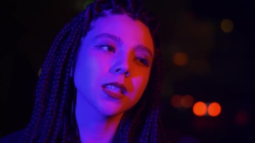 Young Woman Lit By Blue and Red Light