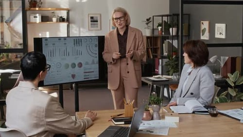 Woman Presenting Graphs and Charts to Two Applauding Colleagues in Modern Office