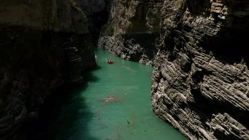 Aerial view of boat riding through canyon