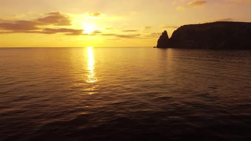 Aerial View on Sunset Over Calm Sea and Volcanic Rocky Shores