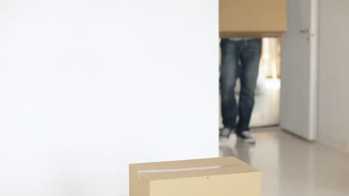 Man Moving Cardboard Boxes in New Home