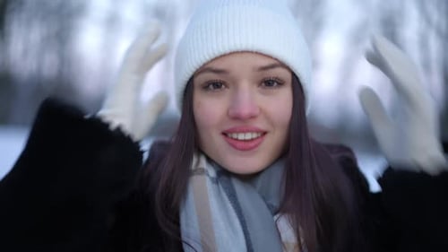 Front View Portrait of Happy Carefree Young Woman Touching Hat in Slow Motion Looking at Camera with