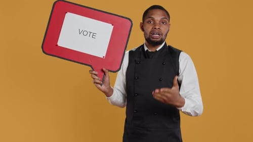 Man Holding Vote Sign Against Yellow Background
