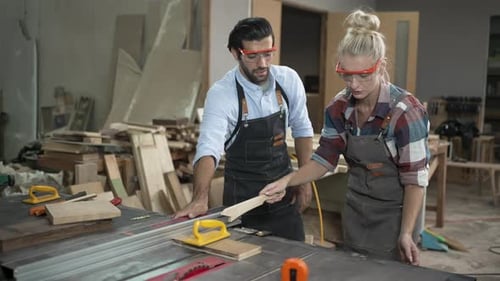 Carpenters are working together at workshop.