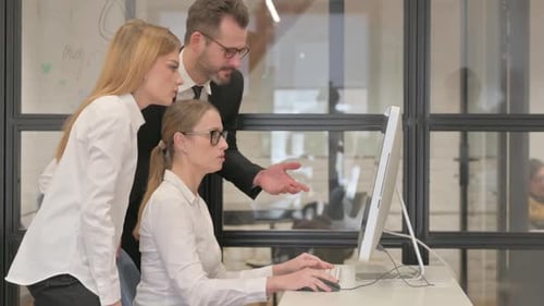 Team Collaborating at Computer in Modern Workplace