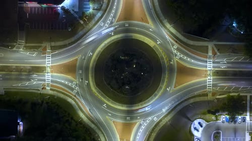 Top View of City Street Traffic on Roundabout Intersection at Night with Fast Moving Cars Timelapse