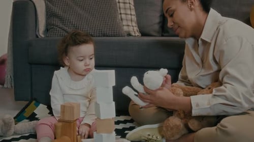 Woman and Child Play with Toys Together Indoors
