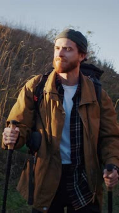 Man Hiking with Backpack and Walking Sticks