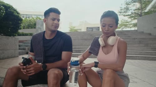 Athletic Man and Woman Resting after Exercise