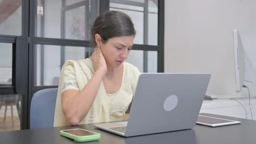 Woman Working at Laptop Rubbing Neck in Office