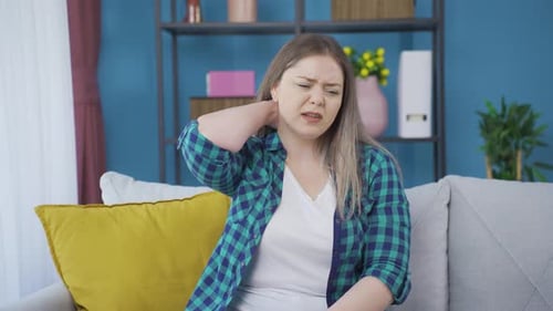 Sick young woman suffering from neck pain.