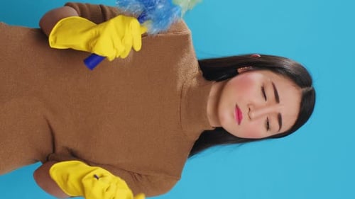 Woman Dusting Furniture Wearing Yellow Rubber Gloves