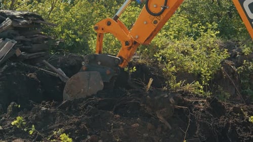 Excavator Digs Soil in Rural Environment