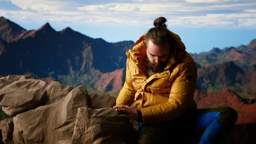 Determined Climber Standing at the Summit Enjoys Peaceful Moment