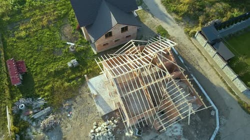 Aerial View of Unfinished Residential House with Wooden Roof Frame Structure Under Construction