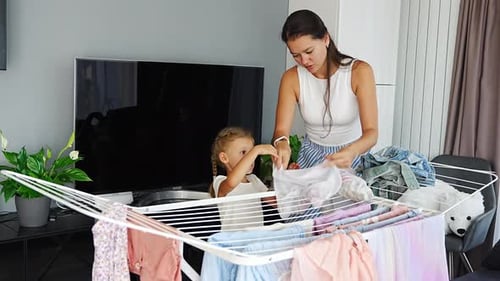 Woman and Girl Folding Laundry Together at Home