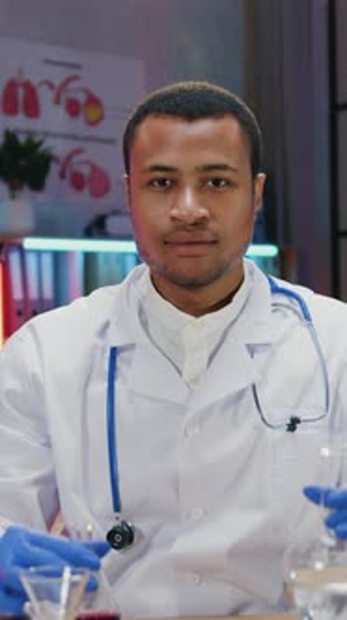 Male Doctor in Lab Coat Holding Beakers