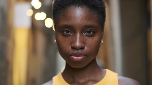 Closeup Shot of Young Woman Looking at Camera and Smiling While Standing on the Street