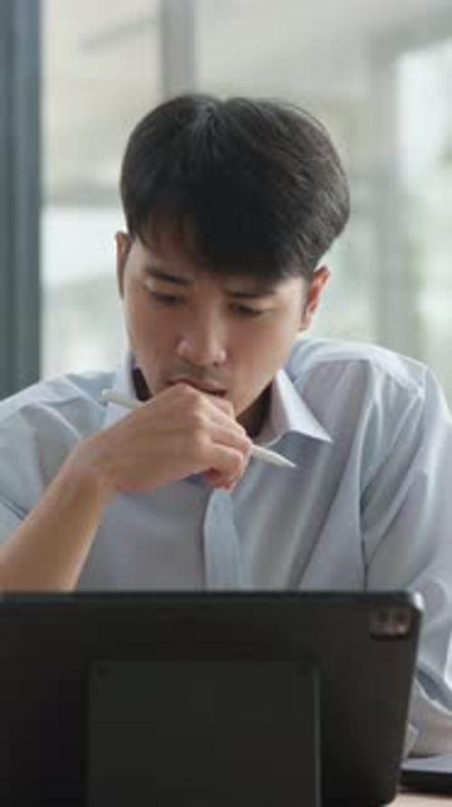 Young Adult Using Tablet With Stylus in Office