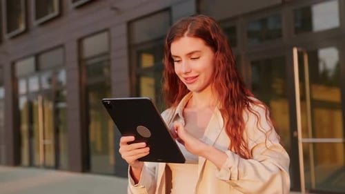 Female Student Holding a Tablet Standing Near the Business Center