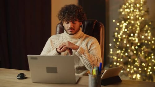 Curly Young Man Rubbing His Hands While Looking at the Laptop Screen Cheerful Guy is Working