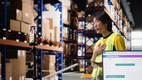 Asian Worker Promoting the Large Business Industrial Warehouse on a Vlog
