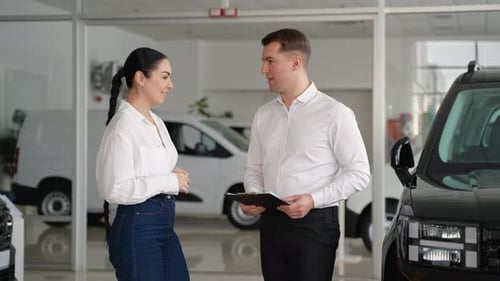 Woman Receives Car Keys from Salesman in Dealership