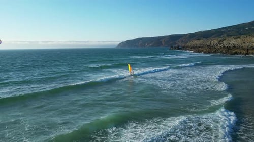 Flying along the sea following a windsurfer riding waves at guincho beach,Guincho beach It is very