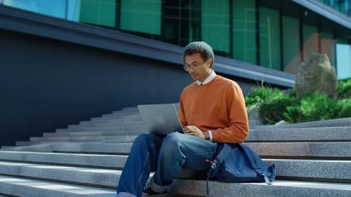 Young Adult Celebrates Success With Laptop Outdoors