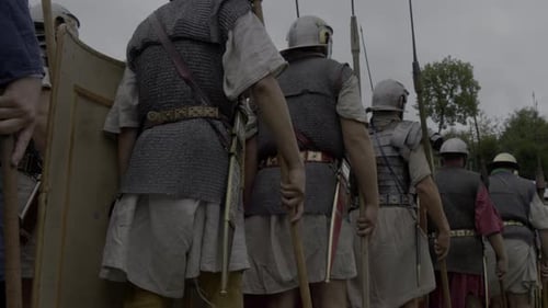 A Group of Roman Soldiers Marching in a Line Near a Historic Monument