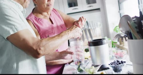 Senior Couple Preparing Food in Kitchen