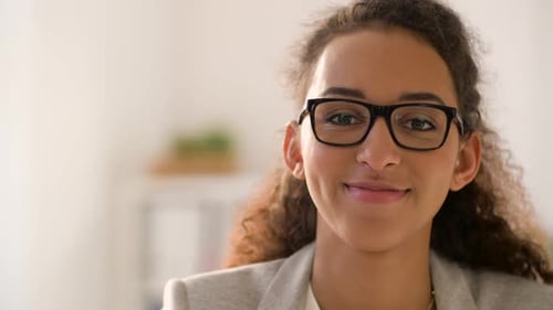Smiling woman with glasses looks at the camera