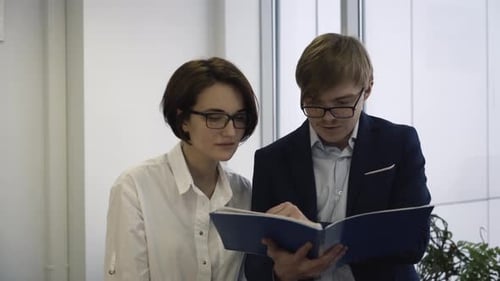 Business Colleagues Analyzing Documents Together in Office