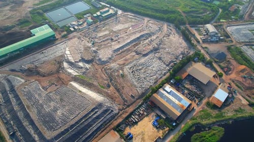 Drones are flying over large garbage pile of plastic waste